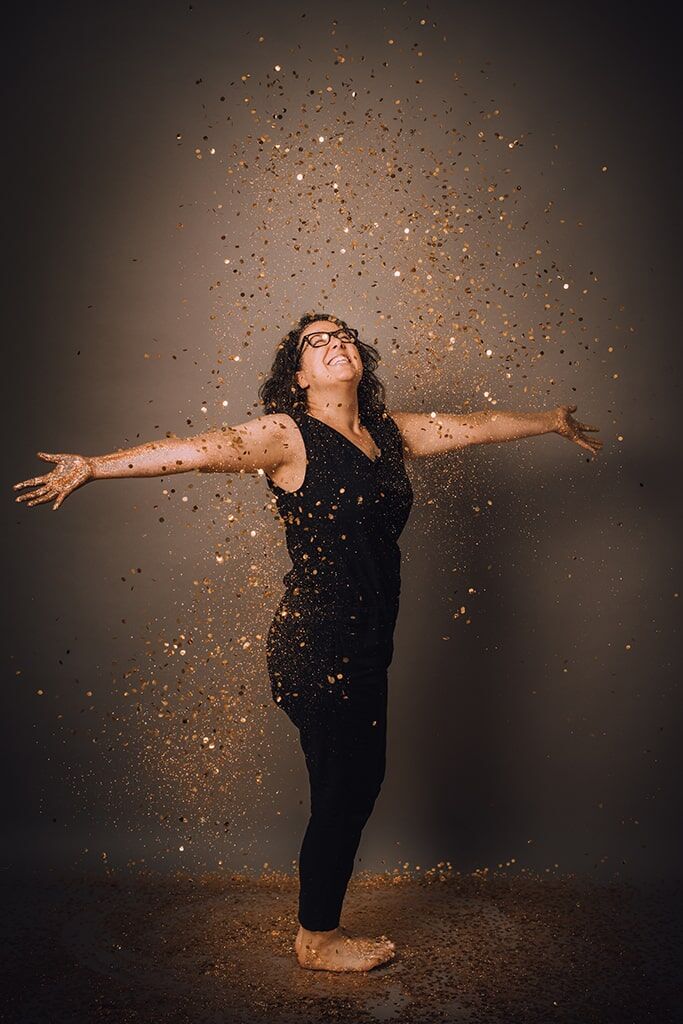 Bild von Frau, auf die Glitzerplättchen herabfallen Bild von Frau, auf die Glitzerplättchen herabfallen