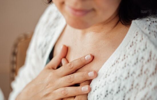 Bild von Frau mit Händen auf dem Herzen